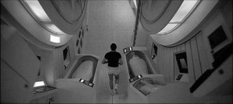  Imagem do interior da nave de 2001: no centro um dos astronautas correndo normalmente devido à simulação da aceleração gravitacional, e, em ambos os lados do corredor, as câmaras de hibernação